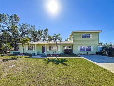 Two-story house with a green exterior, landscaping, and driveway at 6008 49Th N Ave, Kenneth City, FL 33709