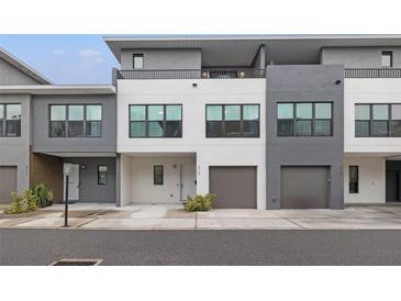 Modern two-story townhome with attached garage and neutral color palette at 8709 Palm Ranches Pl, Tampa, FL 33614