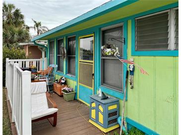 Colorful beach cottage with a porch and deck at 18006 4Th E St, Redington Shores, FL 33708