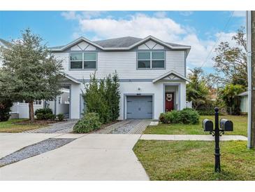 Two-story house with gray siding, attached garage, and landscaped yard at 2704 W Gray St # B, Tampa, FL 33609