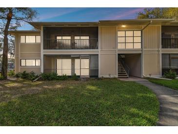 Condo exterior featuring a screened balcony and well-manicured lawn at 6012 Laketree Ln # A, Temple Terrace, FL 33617