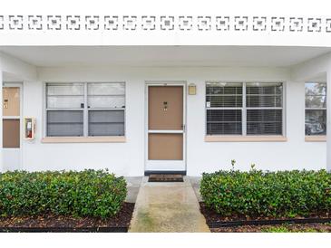 Front entrance of condo building, featuring landscaping and individual unit entrances at 1000 79Th N Ave # 102, St Petersburg, FL 33702
