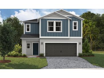 Two-story home with blue siding, dark gray garage door, and landscaping at 37268 Sagemoor Dr, Zephyrhills, FL 33541