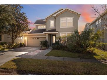 Two-story house with gray siding, attached garage, and landscaping at 8442 Lagerfeld Dr, Land O Lakes, FL 34637