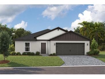 Single-story home with dark brown garage door and landscaping at 2112 Stillview Pass, Zephyrhills, FL 33541