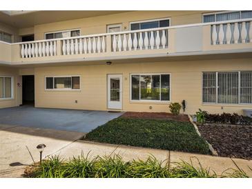 Attractive two-story building with a well-manicured lawn and shrubbery in front of the entrance of unit 11 at 2221 Swedish Dr # 11, Clearwater, FL 33763