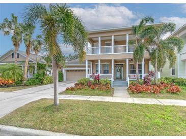 Two-story house with a neutral exterior, a large front porch, and a two-car garage at 406 Manns Harbor Dr, Apollo Beach, FL 33572