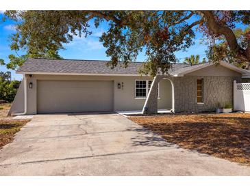 Updated one-story home with gray exterior, attached garage, and mature landscaping at 801 54Th S Ave, St Petersburg, FL 33705