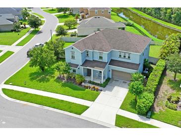 Two-story house, gray roof, light blue walls, landscaping, and driveway at 3238 Mela Ct, Holiday, FL 34691