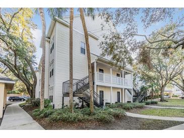 Two-story building with white siding, stairs, and landscaping at 3270 Haviland Ct # 304, Palm Harbor, FL 34684