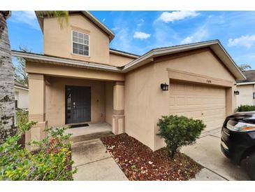 Two-story house with attached garage and landscaping at 15406 Peach Stone Pl, Ruskin, FL 33573