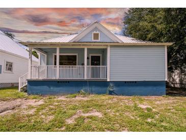 Light blue house with a metal roof, front porch, and small yard at 2314 E 12Th Ave, Tampa, FL 33605
