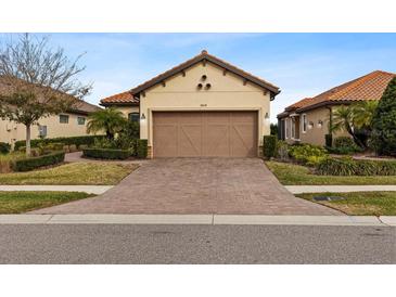 House exterior featuring a two-car garage and well-manicured landscaping at 8424 Alberata Vista Dr, Tampa, FL 33647