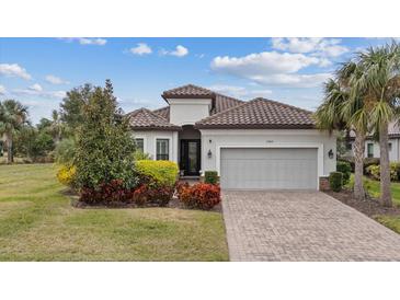 Single-story home with tile roof, landscaping, and a two-car garage at 11465 Bitola Dr, Odessa, FL 33556