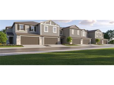 Modern townhouses with attached garages and landscaped lawns at 32208 Jamaica Caper Way, San Antonio, FL 33576