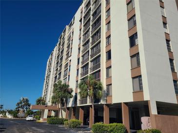 Multi-story building with parking and palm trees at 255 Dolphin Pt # 511, Clearwater Beach, FL 33767