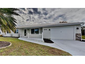 White house with a white picket fence and a two-car garage at 4411 Mongite Rd, North Port, FL 34287
