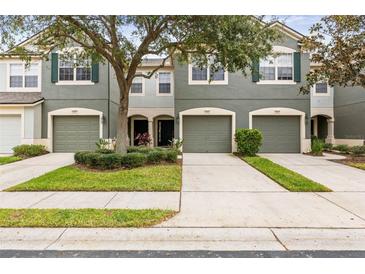 Front view of charming townhome with 3-car garage and well-manicured landscaping at 4842 Pond Ridge Dr, Riverview, FL 33578