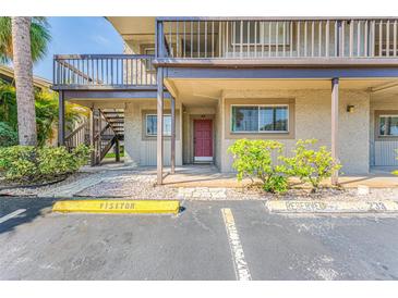 Condo building exterior featuring a walkway, stairs, and parking at 6332 Newtown Cir # 32A1, Tampa, FL 33615