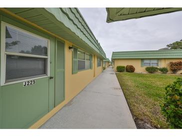 Exterior view of building with walkway and landscaping at 102 Cambridge Trl # 225, Sun City Center, FL 33573