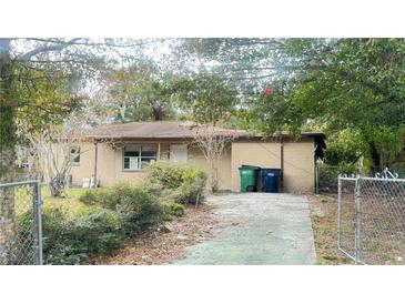 Tan brick ranch home with driveway and yard at 6405 Riverbend Cir, Tampa, FL 33610