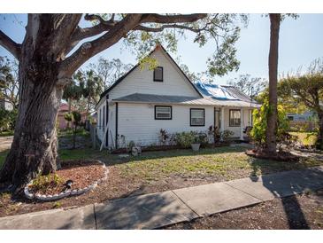 White house with a gable roof, mature trees, and a small front yard at 7408 S Elliott St, Tampa, FL 33616