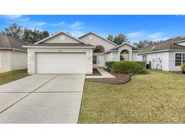 House exterior featuring a two-car garage and well-manicured lawn at 4605 Lisette Cir, Brooksville, FL 34604