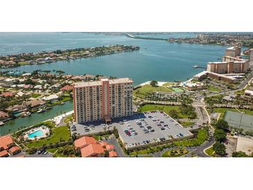 Aerial view of waterfront condo building with pool, parking, and tennis court at 4900 Brittany S Dr # 701, St Petersburg, FL 33715