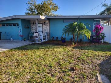 Updated teal home with landscaped yard, featuring a new front door and walkway at 16108 5Th E St, Redington Beach, FL 33708