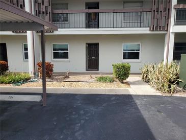 Condo building exterior with parking and landscaping at 5197 Silent Loop # 121, New Port Richey, FL 34652