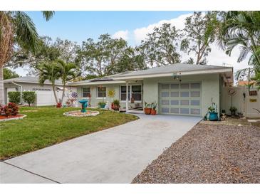 Quaint house with solar panels and a nicely landscaped front yard at 1611 San Charles Dr, Dunedin, FL 34698