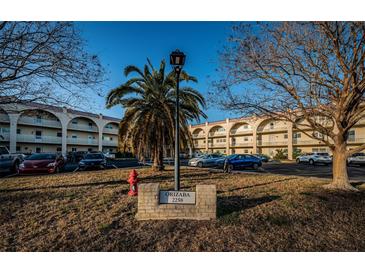 Orizaba condos complex with manicured lawn, trees, and ample parking for residents and guests at 2258 World Parkway W Blvd # 8, Clearwater, FL 33763