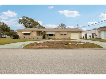 Ranch style home with a large driveway and mature landscaping at 6388 21St N Ave, St Petersburg, FL 33710