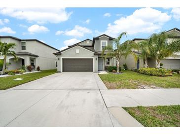 Two-story house with a two-car garage and landscaped lawn at 9512 Lemon Drop Loop, Ruskin, FL 33573