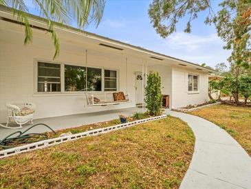 White single story home with porch swing and landscaped yard at 9909 48Th N Ave, St Petersburg, FL 33708
