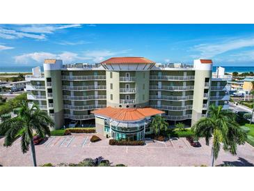 Exterior of a multi-story building with parking and palm trees at 11605 Gulf Blvd # 302, Treasure Island, FL 33706