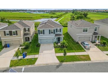 Three houses with solar panels, two-car garages, and landscaped yards at 17048 Oval Rum Dr, Wimauma, FL 33598