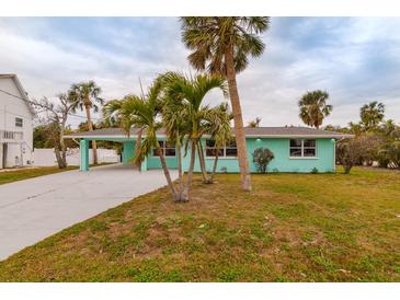 Quaint teal house nestled amongst palm trees at 214 85Th St, Holmes Beach, FL 34217