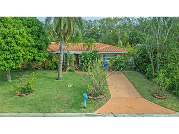 Single-story home with a terracotta roof and lush landscaping at 263 Overbrook E St, Largo, FL 33770