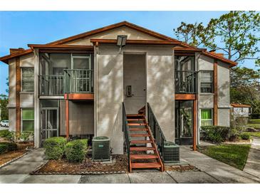 Two-story condo building with balconies and a landscaped yard at 3455 Countryside Blvd # 34, Clearwater, FL 33761