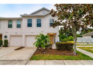 Two-story townhome with attached garage and landscaped front yard at 4533 Ashburn Square Dr # 4533, Tampa, FL 33610