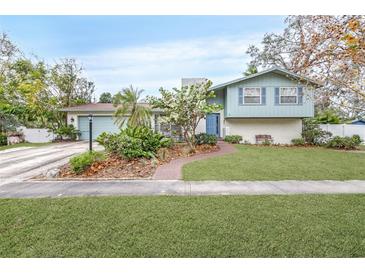 Ranch style home with light blue exterior, brick accents, and landscaped yard at 509 Oakhurst St, Brandon, FL 33511