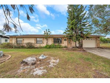 Single-story house with a brown roof, stone accents, and a spacious yard at 6327 5Th Street E Cir, Bradenton, FL 34203