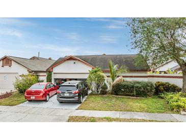 House exterior featuring a two-car garage and well-maintained landscaping at 6931 Silvermill Dr, Tampa, FL 33635