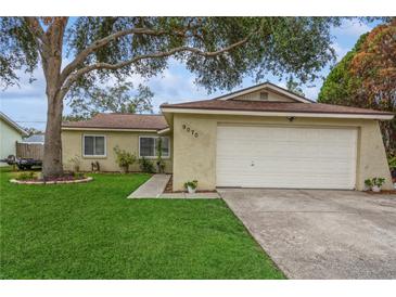 House exterior featuring a one-story house with a two-car garage and well-maintained lawn at 9070 Bryan Dairy Rd, Seminole, FL 33777