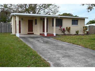 Ranch-style home with carport, landscaped lawn, and mature trees at 11798 104Th St, Largo, FL 33773