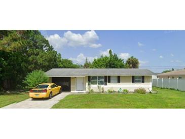Ranch-style home with a well-maintained lawn and driveway at 205 Granada Blvd, North Port, FL 34287