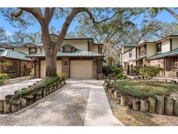 Two-story townhome with attached two-car garage, landscaping, and walkway at 2670 Sequoia Ter # 1406, Palm Harbor, FL 34683