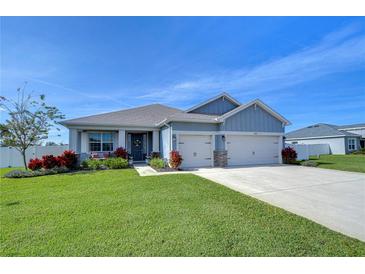 One-story home with gray siding, two-car garage, and landscaped lawn at 4439 Devinshire Fields Loop, Plant City, FL 33567