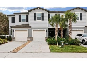 Two-story townhome with attached garage and landscaping at 21428 Darter Rd, Land O Lakes, FL 34638